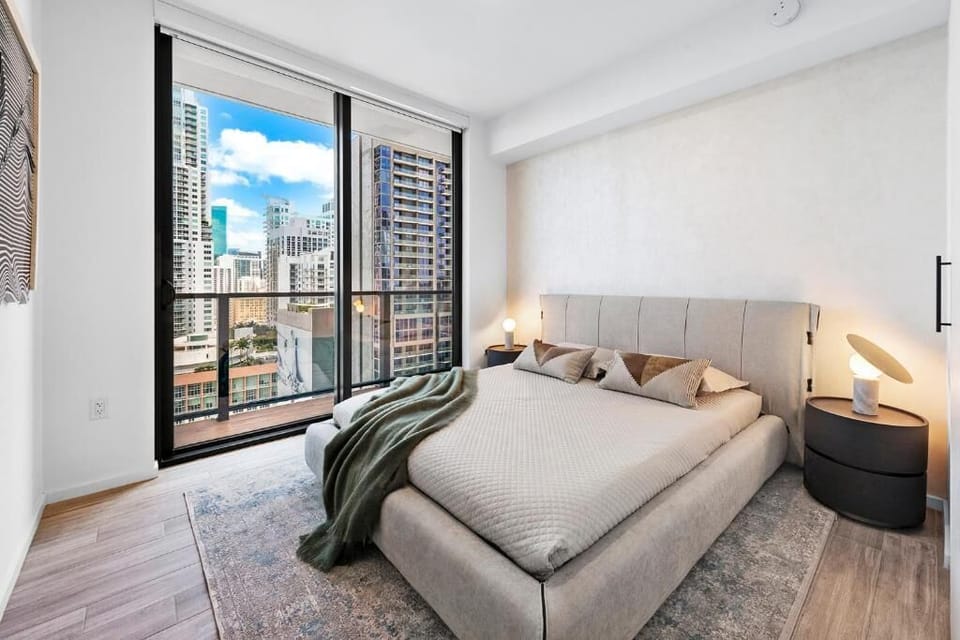 Relax in a designer bedroom framed by downtown skyline views.