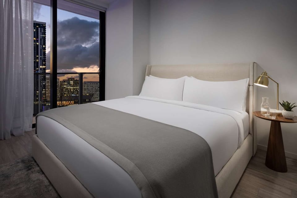 Wake up to soft sunrise hues over the skyline.