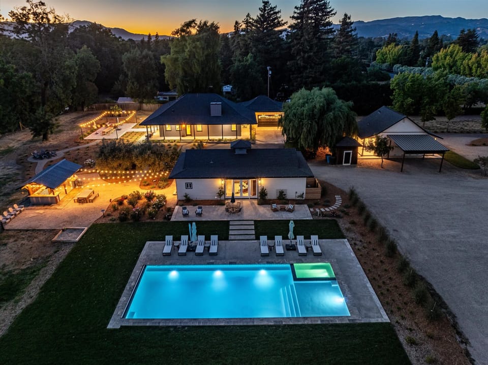 Outdoor Oasis: Stunning poolside retreat surrounded by twinkling lights and lush greenery!