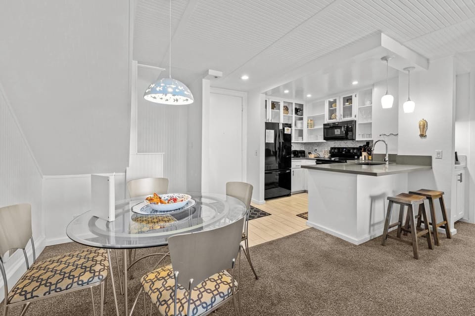 Glass dining table offers enough seating for 4 and 2 additional seats in the kitchen bar