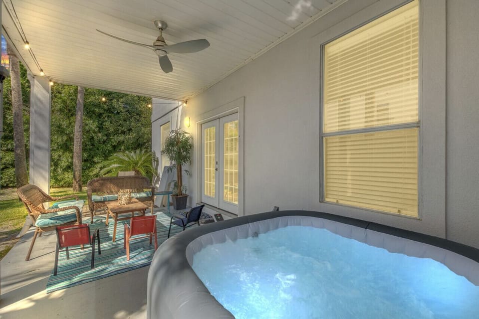 A relaxing back patio with a hot tub, perfect for unwinding and enjoying the outdoors in comfort!