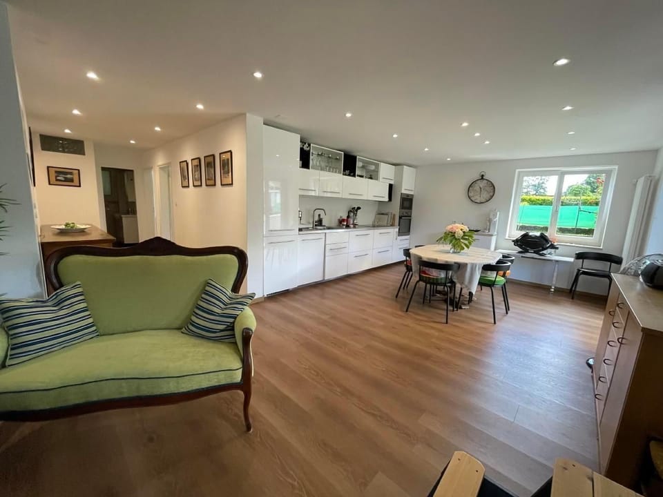 Bright living room with dining table, sitting area, TV and WLAN. 