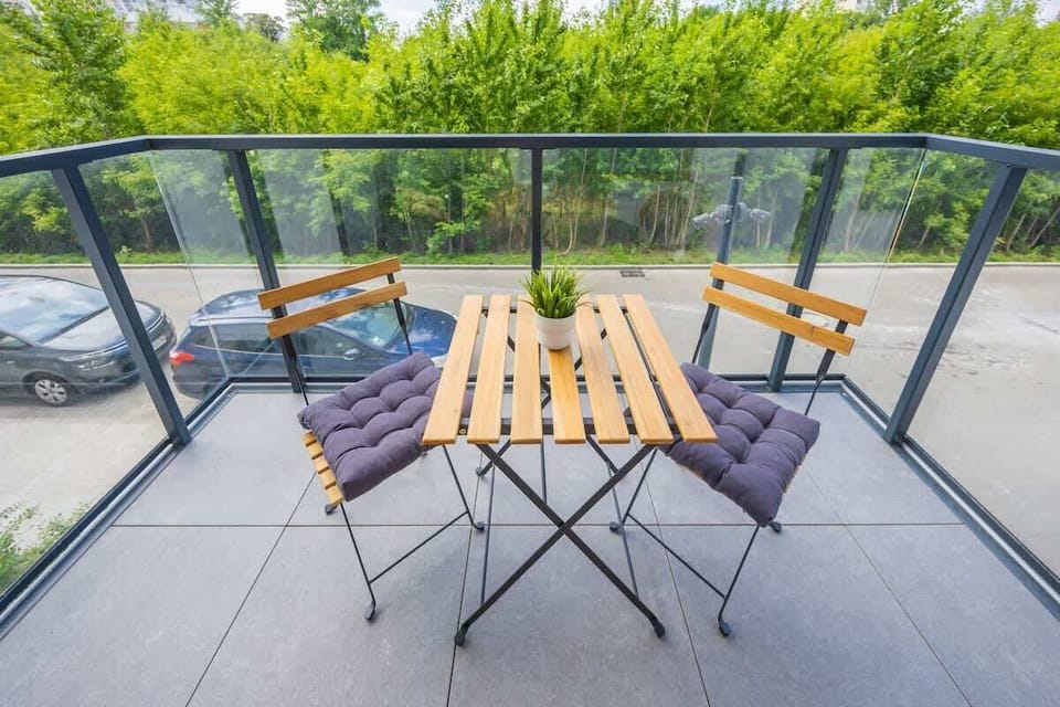 Another balcony view with a broader seating arrangement and glass railings.

