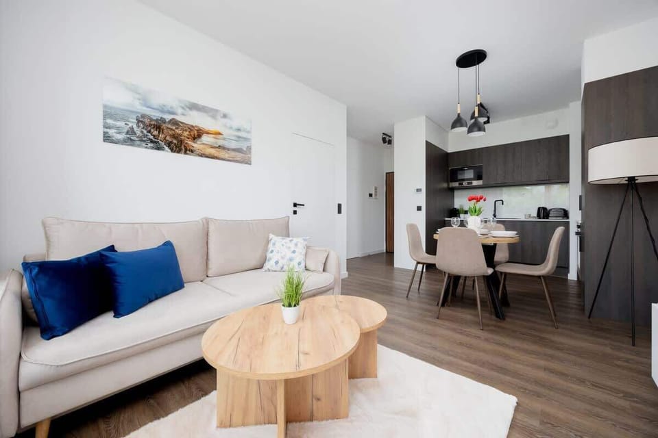 A spacious living room with stylish furniture, open layout, and recessed lighting.
