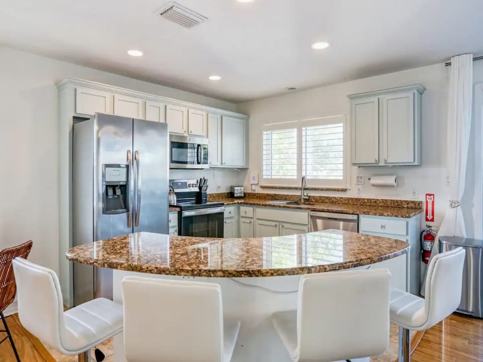 Fully Equipped Kitchen with Stainless Steel Appliances and Breakfast Bar Seating for Four