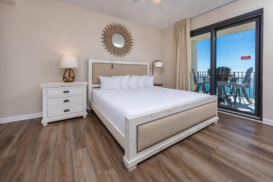 Serene master bedroom featuring a king bed, stylish decor, and beachfront balcony access