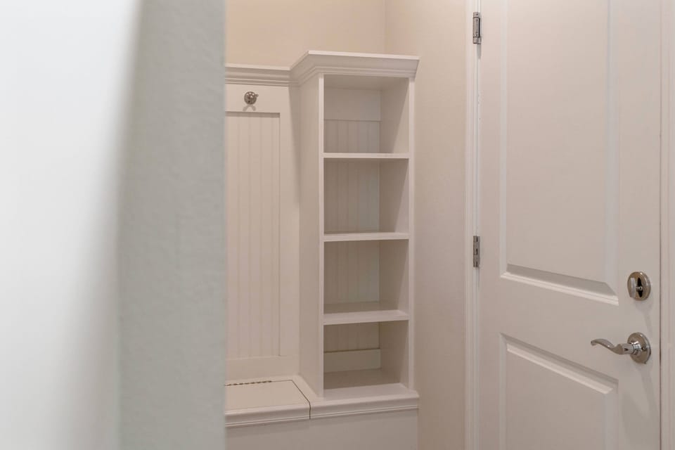 Enter a beautifully designed entryway with a stylish built-in cubby and shelves, ideal for keeping your belongings organized. The soft, neutral wall tones create a warm, inviting atmosphere that enhances your stay.