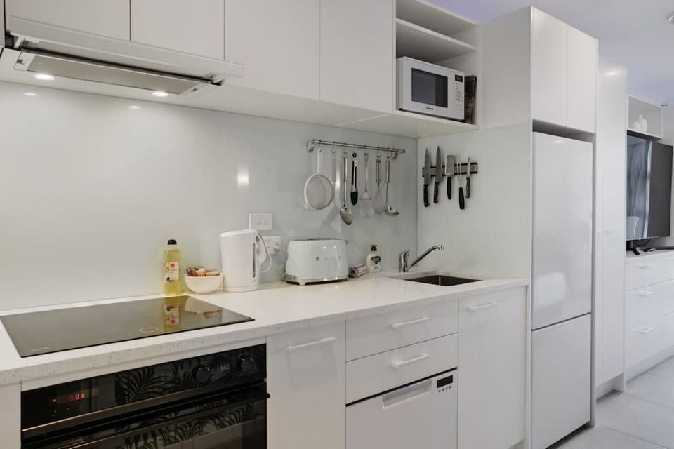 The kitchen has everything you need to cook, including an oven, cooktop, dishwasher, fridge/freezer, and microwave.