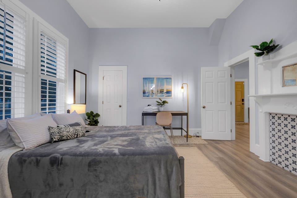 bedroom with queen bed, tv, full bathroom & desk/workspace