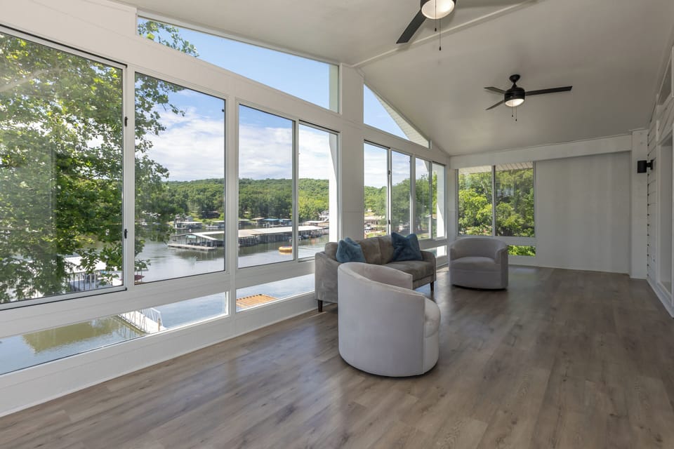 Beautiful sunroom with modern furnishings and bright, lake-front views.