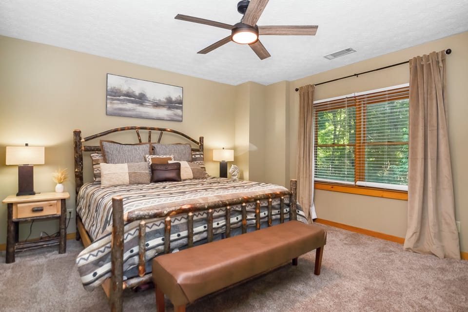 Highlighting the bed, nightstands, and a large window for the natural light.
