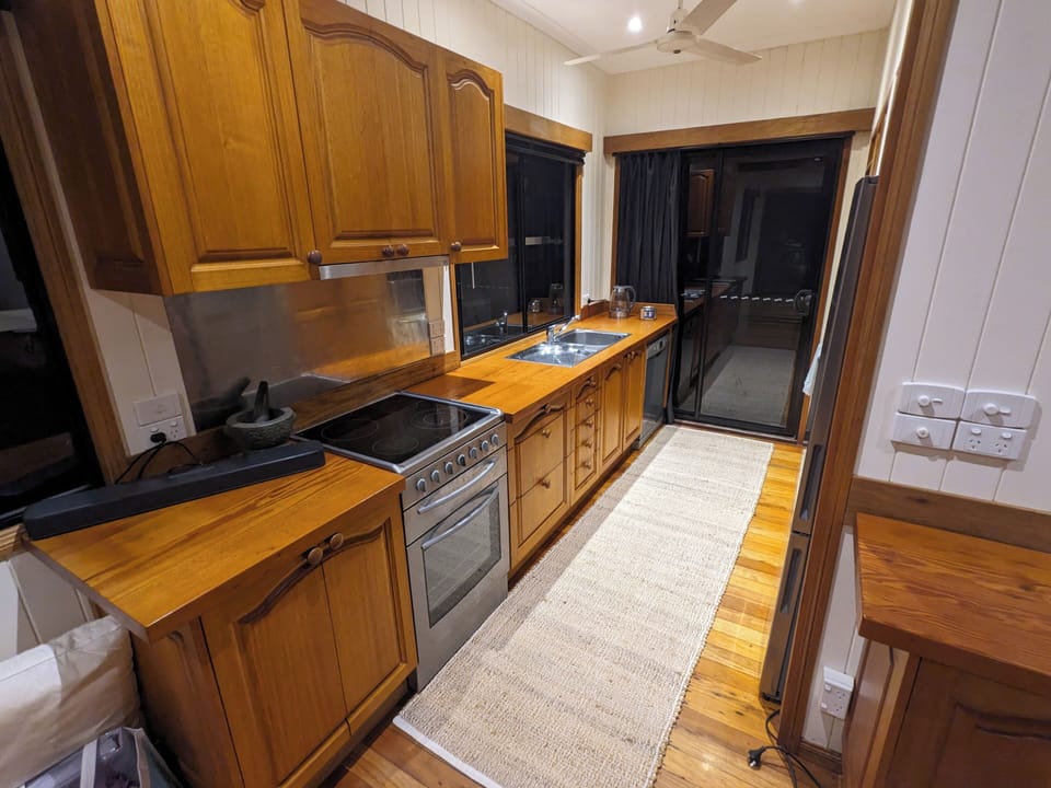 Full kitchen with oven, dishwasher, fridge, microwave, cooking and dining ware.