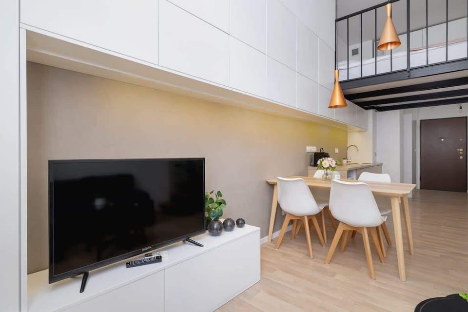 TV and dining area under mezzanine – Smart use of vertical space with modern design.