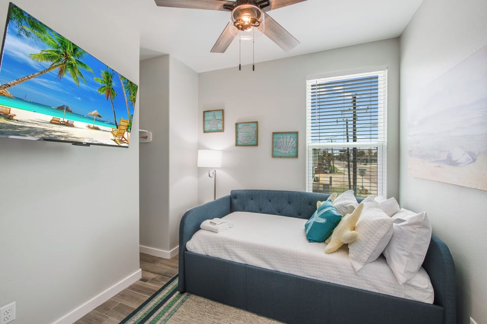 Cozy guest bedroom offering a twin daybed, twin trundle, TV, and private bath.