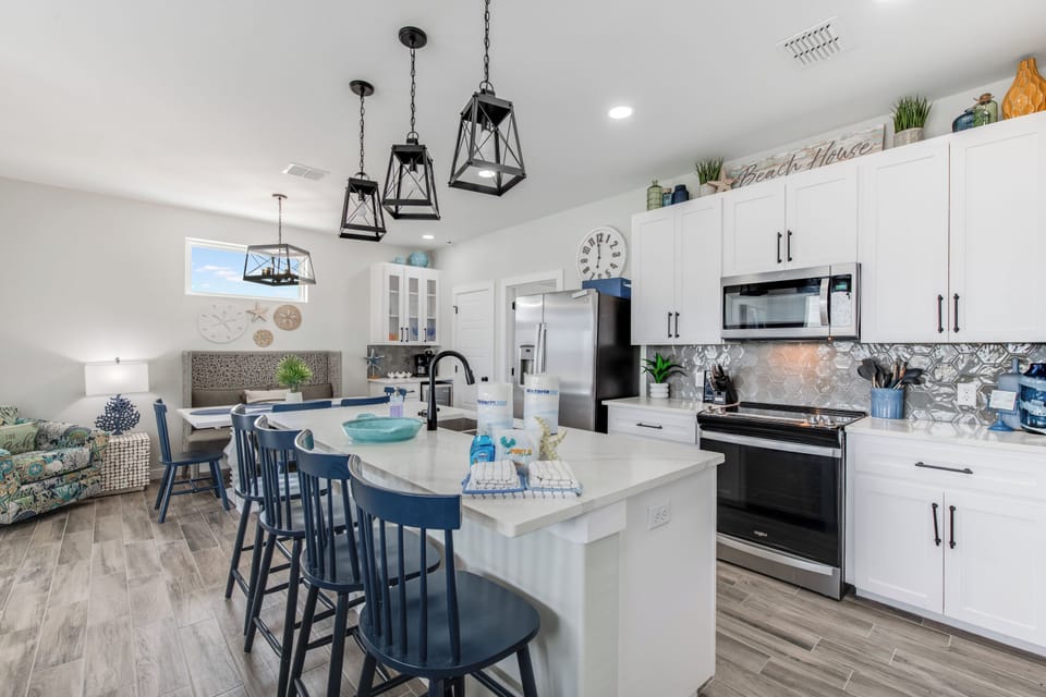 A stylish kitchen island anchors the space, blending function with coastal charm