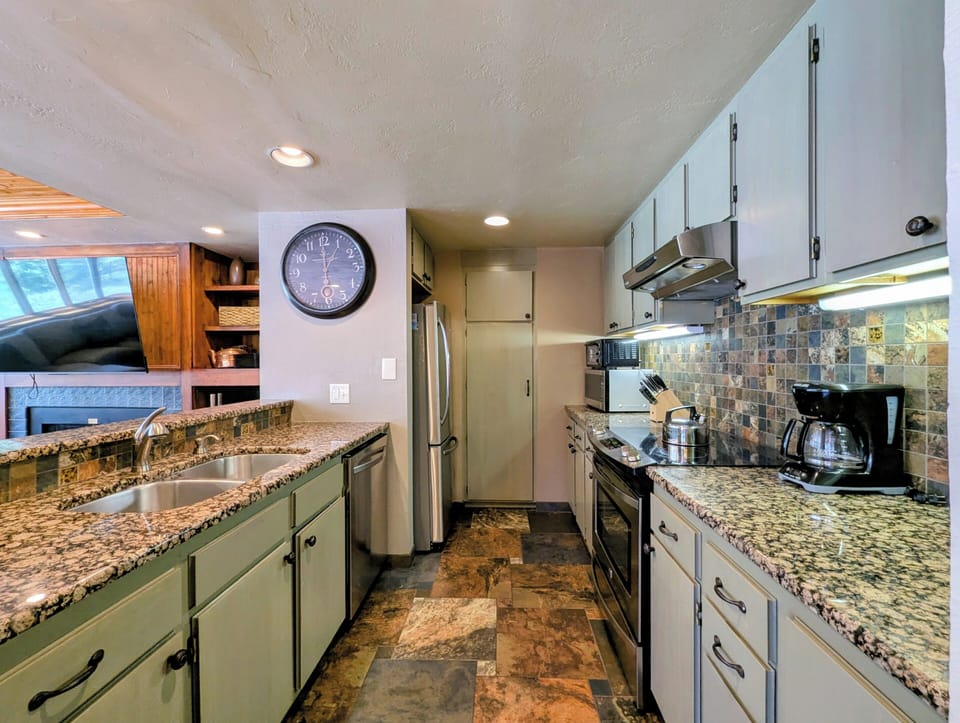 Your fully equipped kitchen features granite countertops, stainless steel appliances, and a charming mosaic backsplash—perfect for preparing memorable meals during your stay.