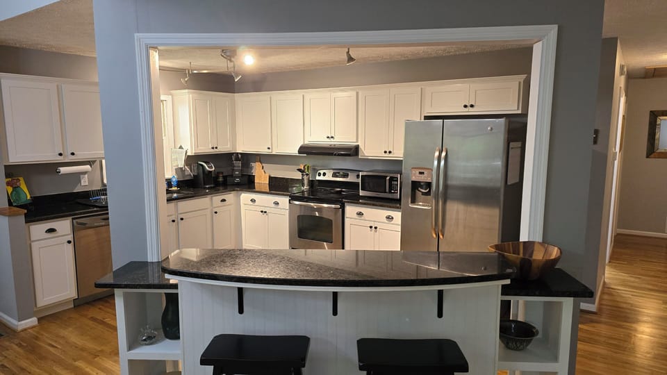 Updated kitchen with granite countertops and island bar.