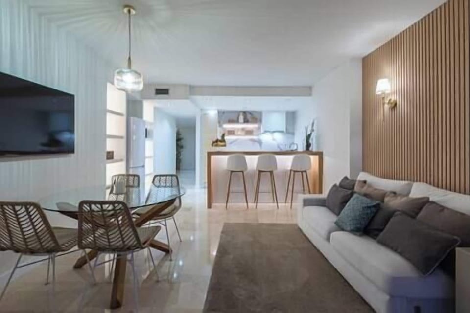 Living-dining room with double sofa, table, chairs, TV and exit to terrace. (2)