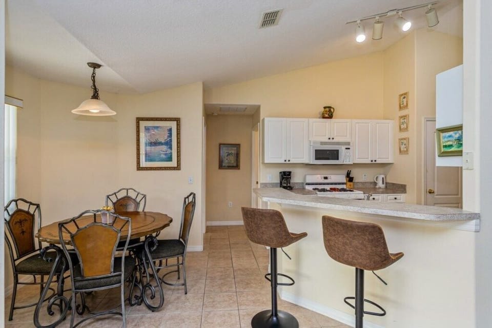Kitchen and breakfast bar area with modern appliances and seating.