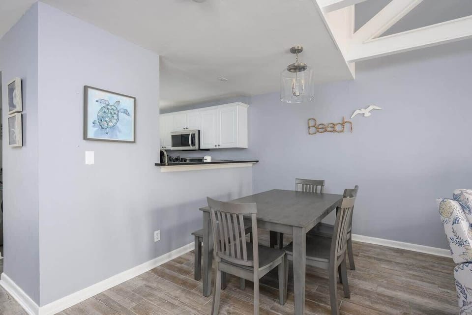 Adjacent to the living area is a functional dining space featuring a dark wood table.