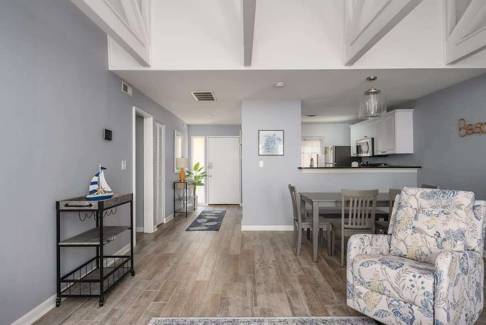 The heart of the home is a spacious living room centered around a cozy gray sofa.