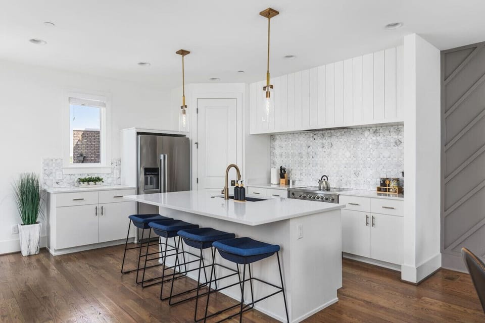 High-end appliances, large pantry, and all the cooking supplies you might need in this bright & fresh kitchen with seating for four at the island.