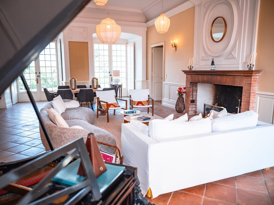 Living room: Sofa + armchairs; XGIMI Halo+ projector; Piano; Large, bright space.