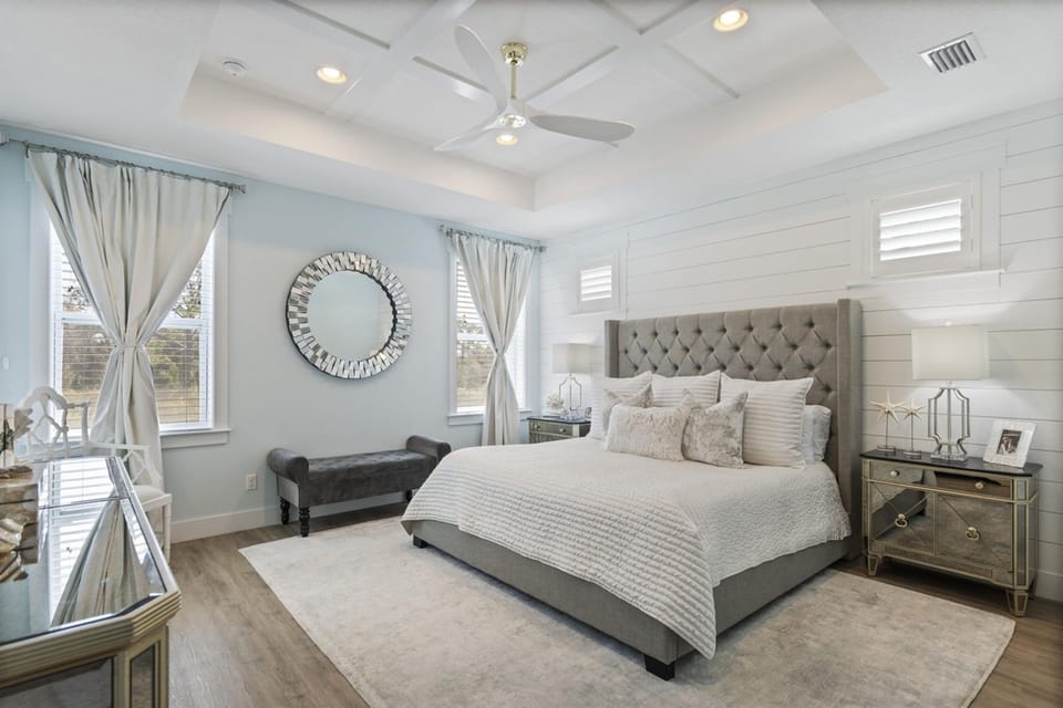 Unwind in your elegant master suite with luxurious linens, soft coastal hues, and gentle ceiling fan keeping you comfortable all night.