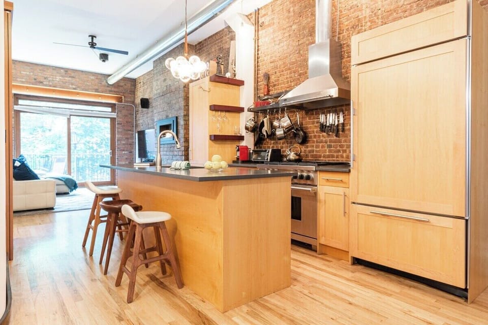 This rare unique loft like open living floor of a 2 floor apartment has a  Master kitchen with Wolf stove Subzero fridge and island bar is a wonderful place to prep dinner for a large family. Kitchen has everything needed to cook. 