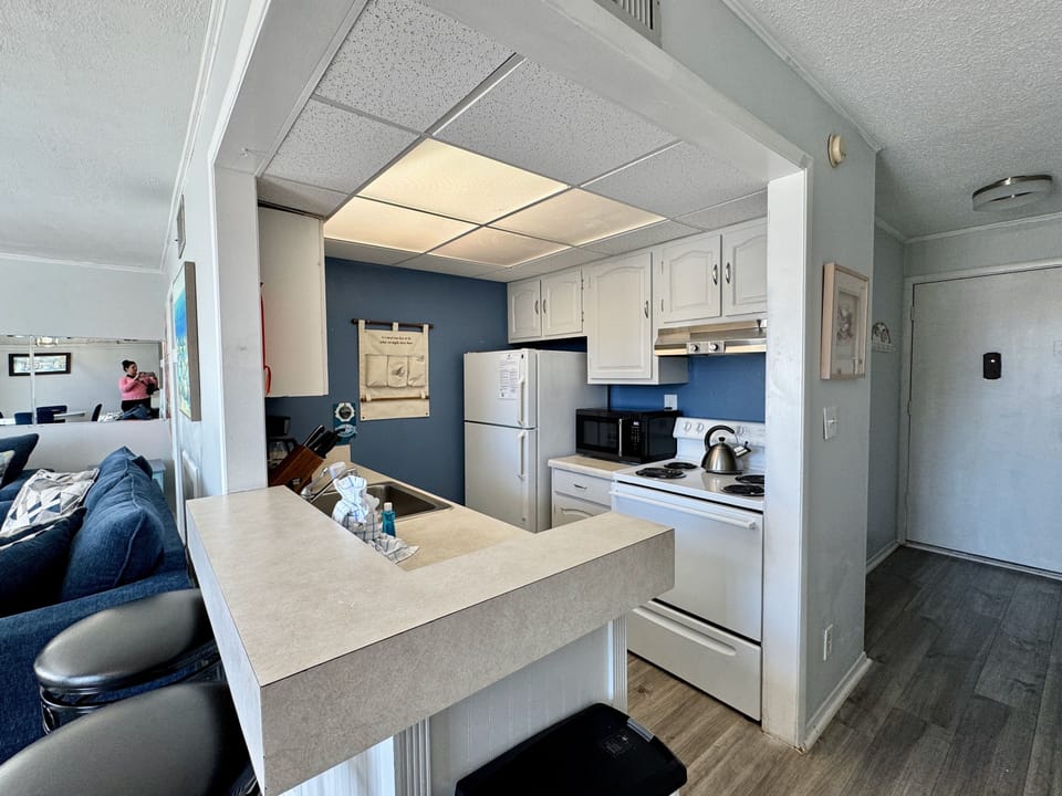 Your fully equipped kitchen features white appliances, granite counters, and an open layout that connects seamlessly to your living area.