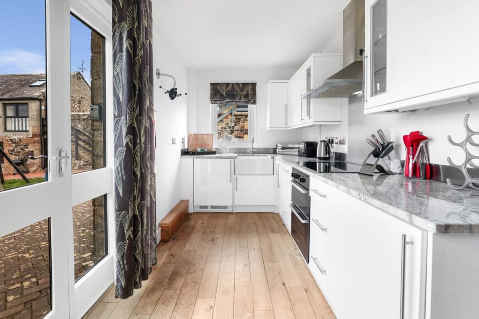 Contemporary kitchen with white cabinetry and granite countertops