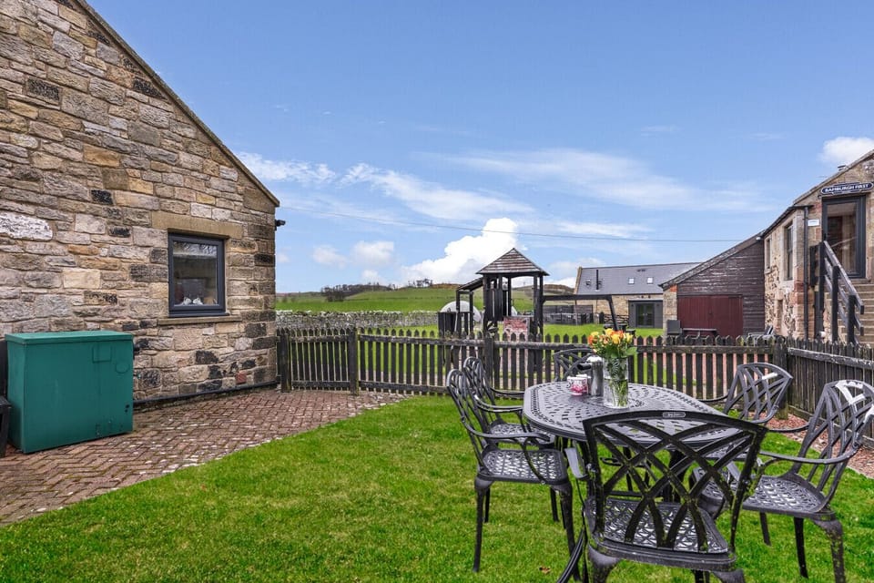 Enclosed garden with outdoor dining area and shared play space beyond