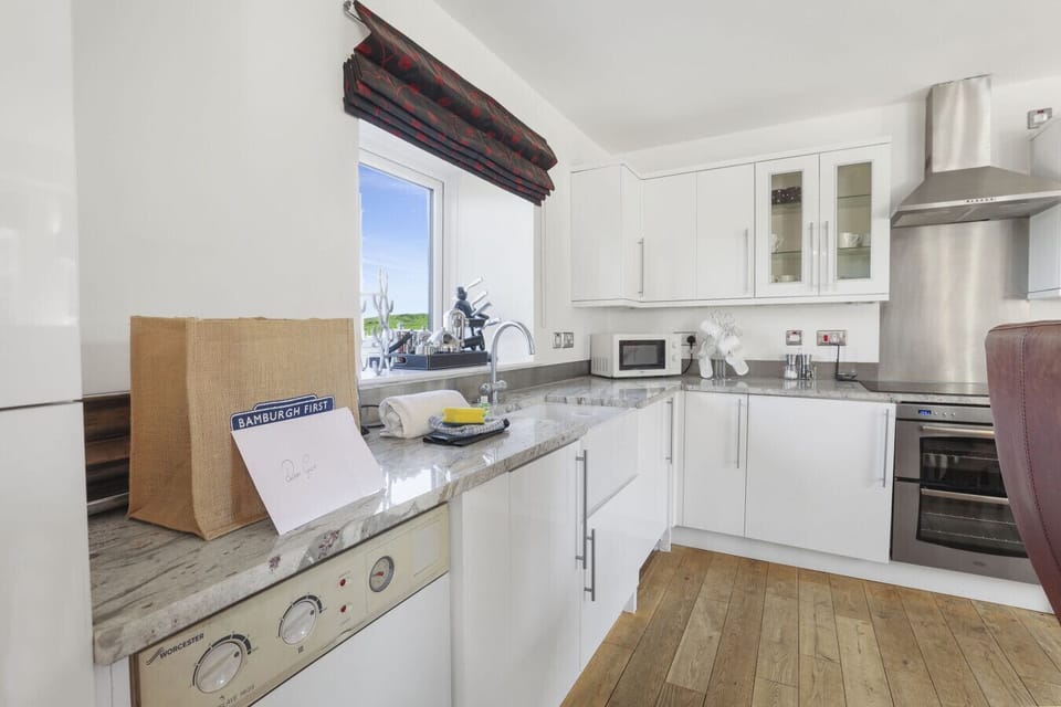 White fitted kitchen with integrated appliances and oak worktops.