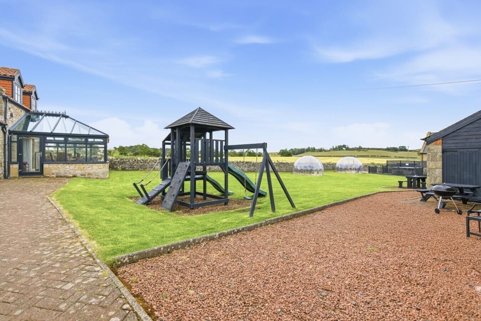 Large shared lawn surrounded by converted stone cottages.