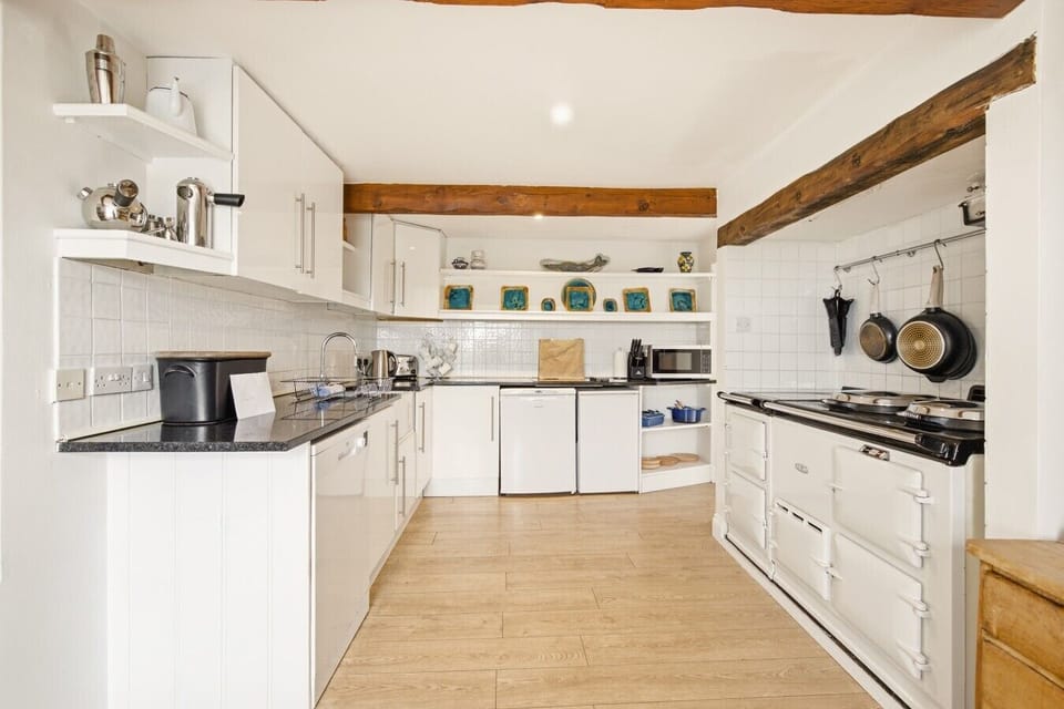 Kitchen with AGA, exposed beams and oak flooring