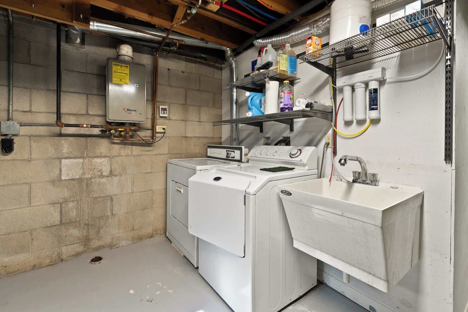 Washer, dryer and utility sink are provided in lower, unfinished level
