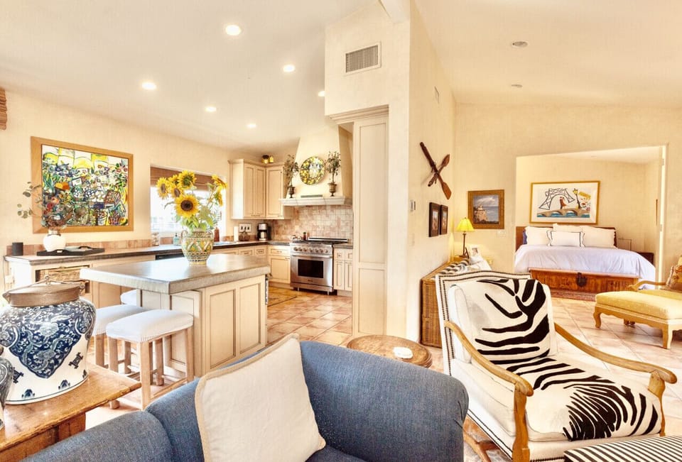 Looking from the living room at the kitchen, additional living space and french door entry to the primary suite.