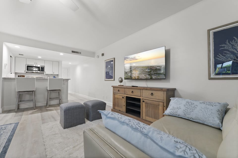 Modern coastal living meets comfort with an open layout, Smart TV, and dining for two beside the fully equipped kitchen.
