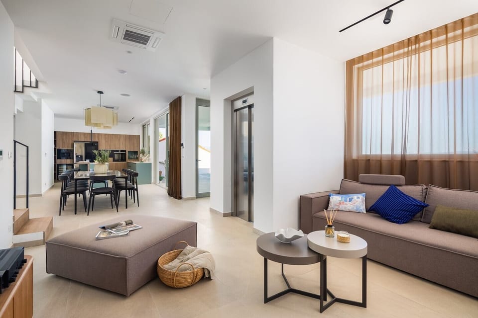 Fully furnished living area with elevator, sofa, a projector with the receiver (as a TV)