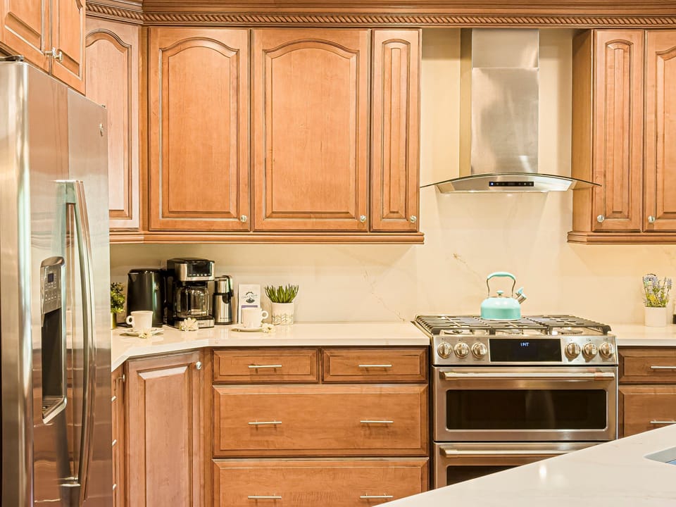 Fully equipped kitchen with 6-burner gas range and double ovens, GE refrigerator with water and ice on the door
