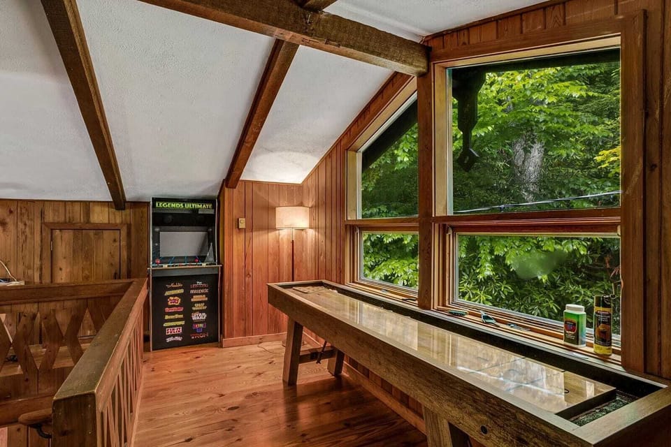 Loft Game Room with a Shuffle Board Table and Arcade Machine