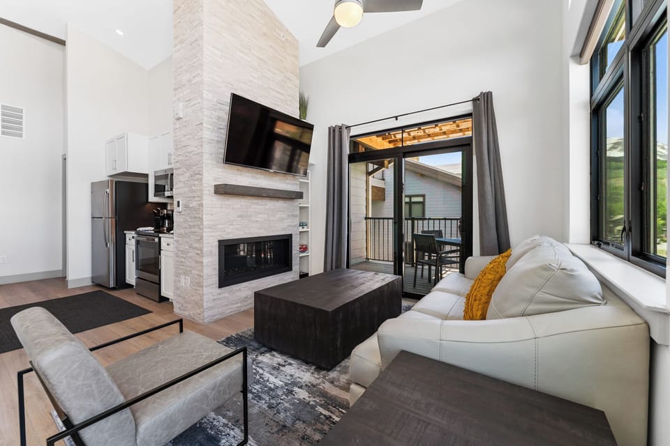 Spacious living area with mounted smart TV and gas fireplace.