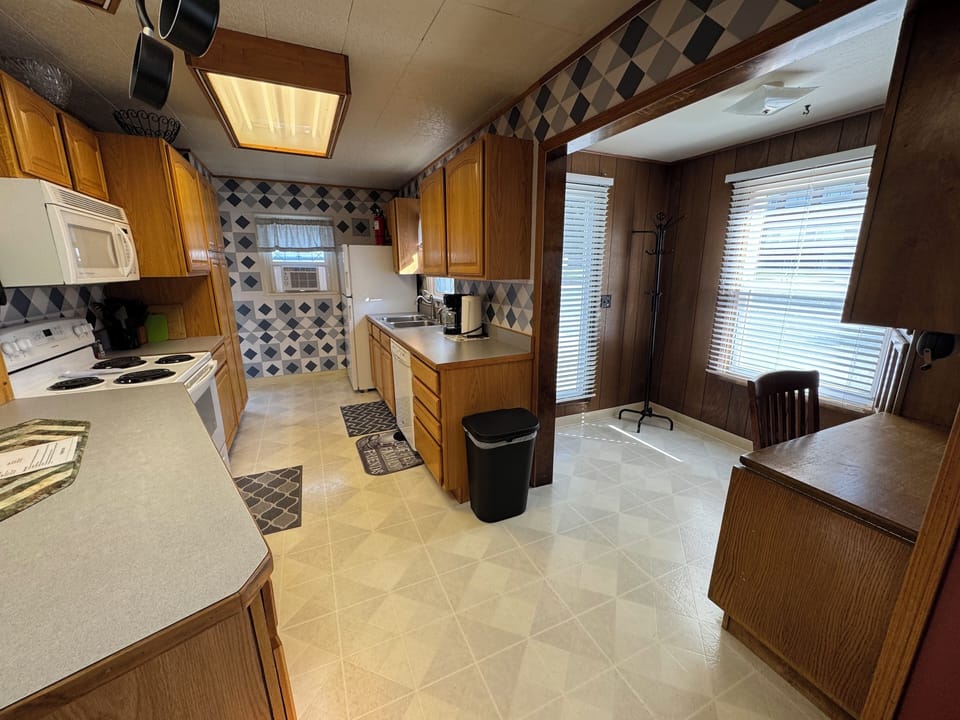 Standing in the living room looking into the kitchen, and small office space.