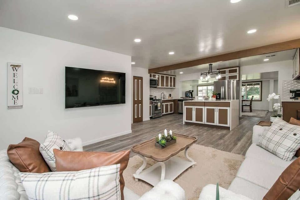 Kick back on the cozy sectional and catch a show on the wall-mounted TV, with the bright open kitchen just beyond—easy for snacking, chatting, and lounging.