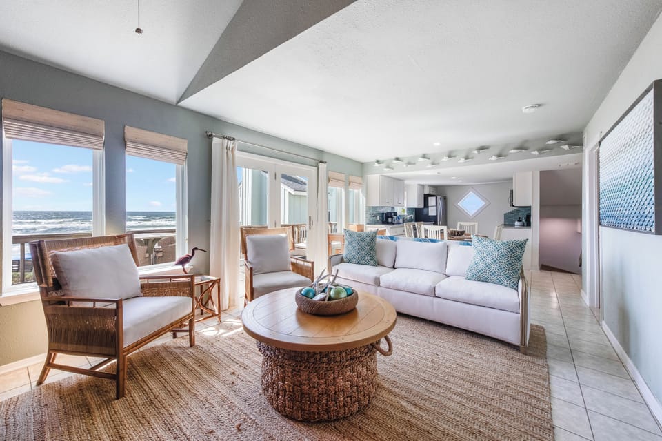 Relax in your coastal haven where ocean waves meet comfort—spacious living room with stunning sea views awaits.