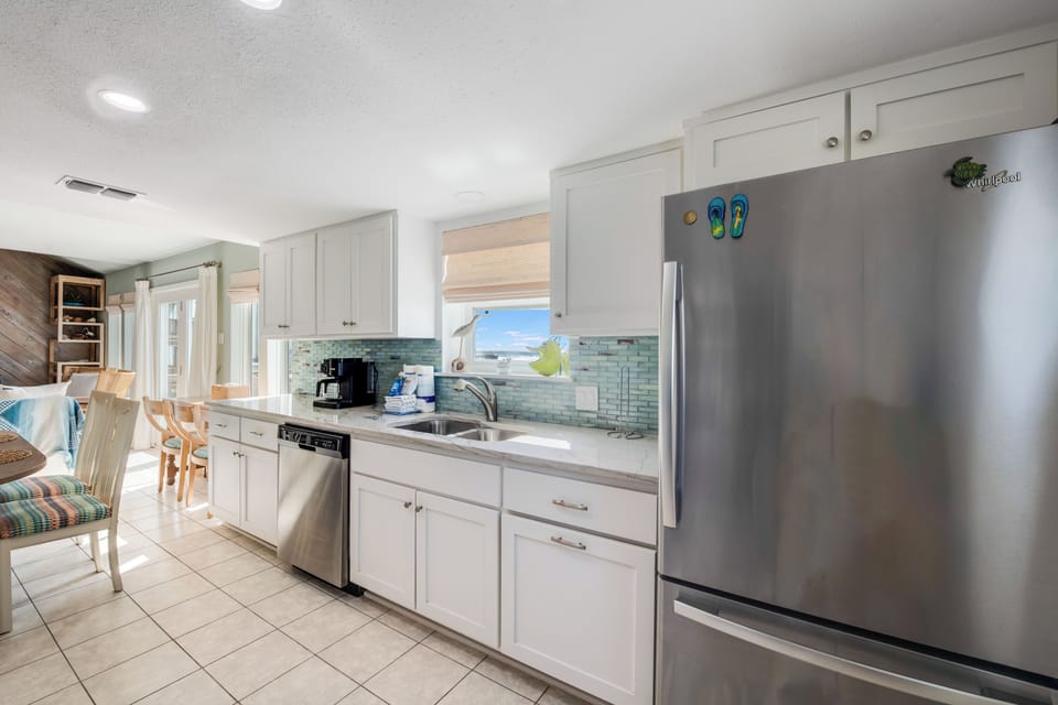 Your bright, fully equipped kitchen awaits with stainless steel appliances and coastal charm for memorable vacation meals.