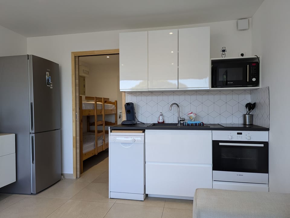Modern kitchen open to the living room, fully equipped with dishwasher, fridge, oven, microwave, and much more