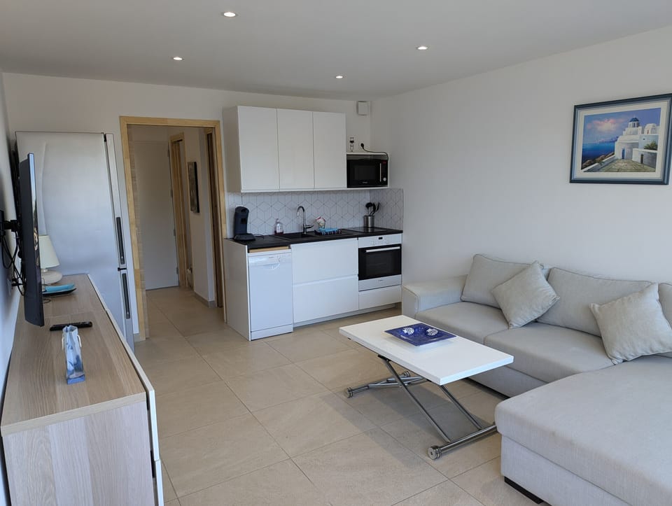 Modern kitchen open to the living room, fully equipped with dishwasher, fridge, oven, microwave, and much more