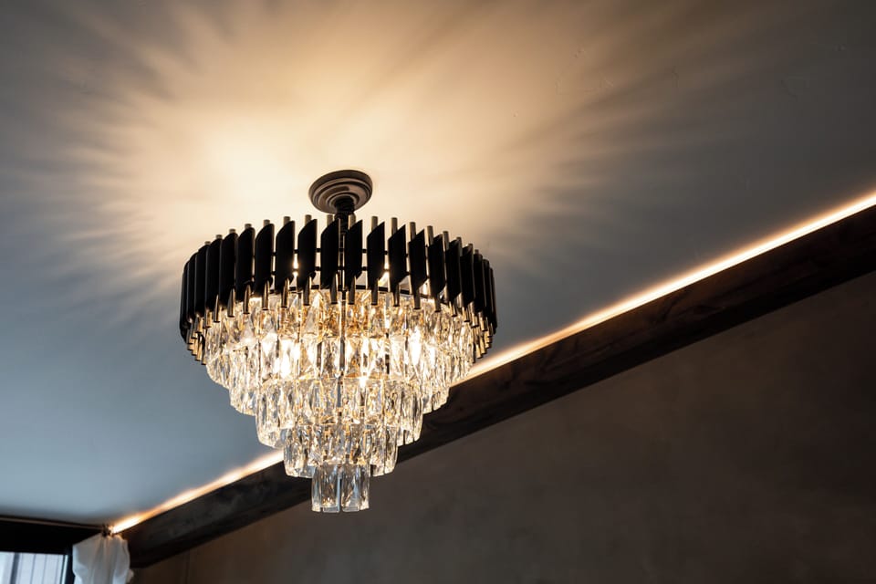 - Stunning crystal chandelier casts light across the bedroom ceiling  
- Adds sparkle and elegance to this rustic-modern mountain retreat  
- Creates cozy ambient glow for peaceful evenings indoors