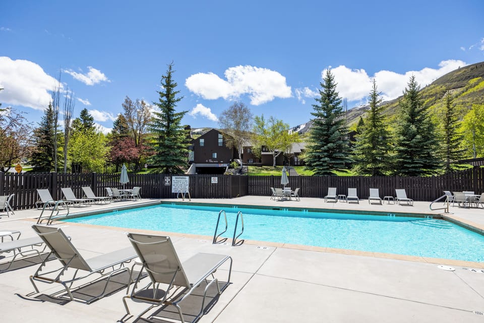 - Refresh with a dip in the outdoor pool surrounded by mountain views  
- Lounge on sunbeds under the clear blue sky and pine trees  
- Relax after exploring nearby trails and scenic landscapes